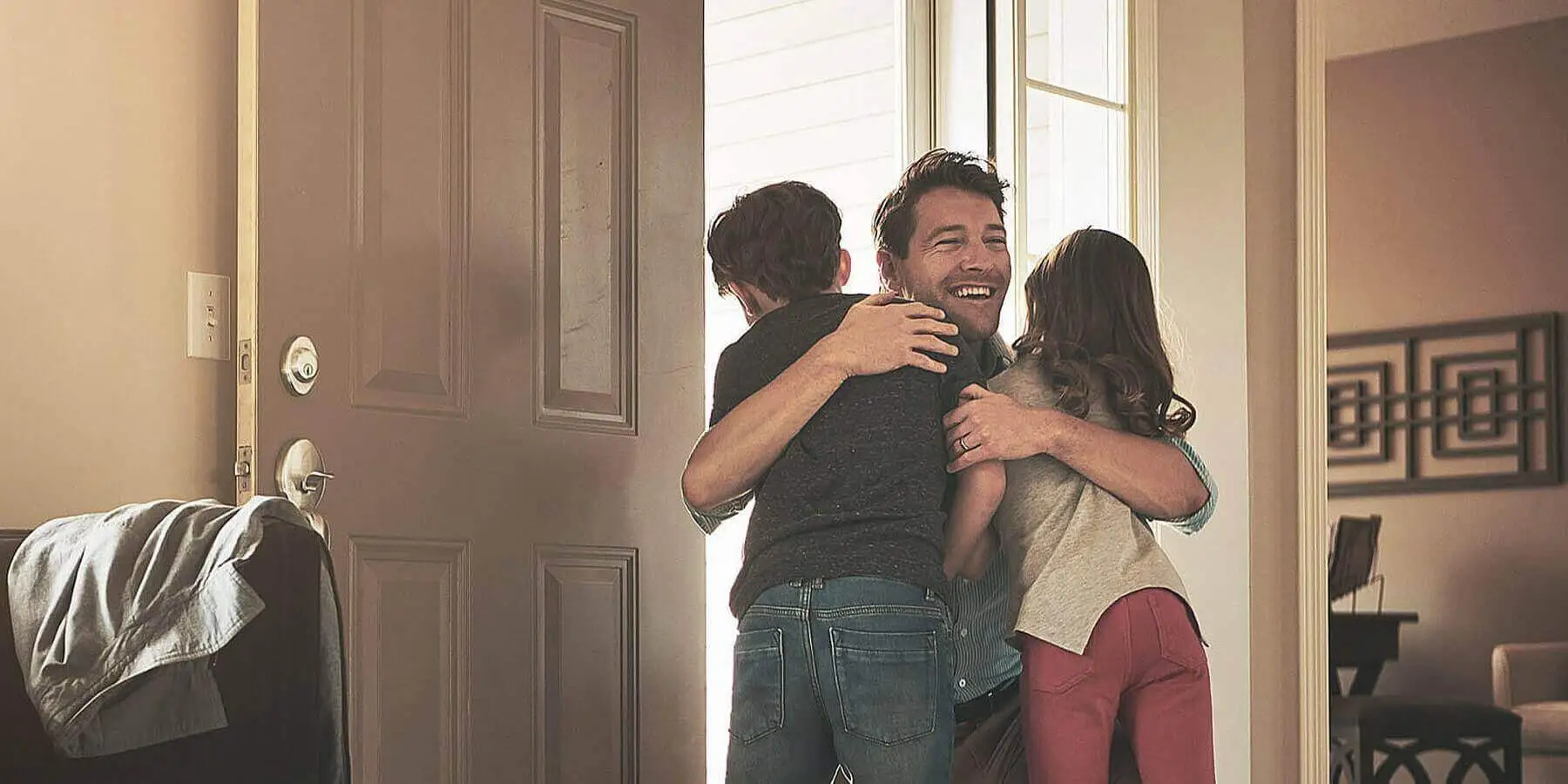 man hugging children